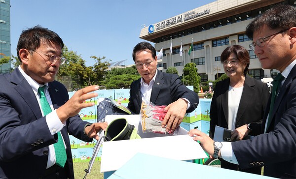 이날 행사에 참석한 김진우 하나은행 중앙영업그룹 부행장(사진 왼쪽에서 첫번째)이 유정복 인천시장(사진 가운데)과 함께 폐지 수거 어르신을 위한 행복상자 구성품을 살펴 보고 있다.  [사진=하나금융그룹]